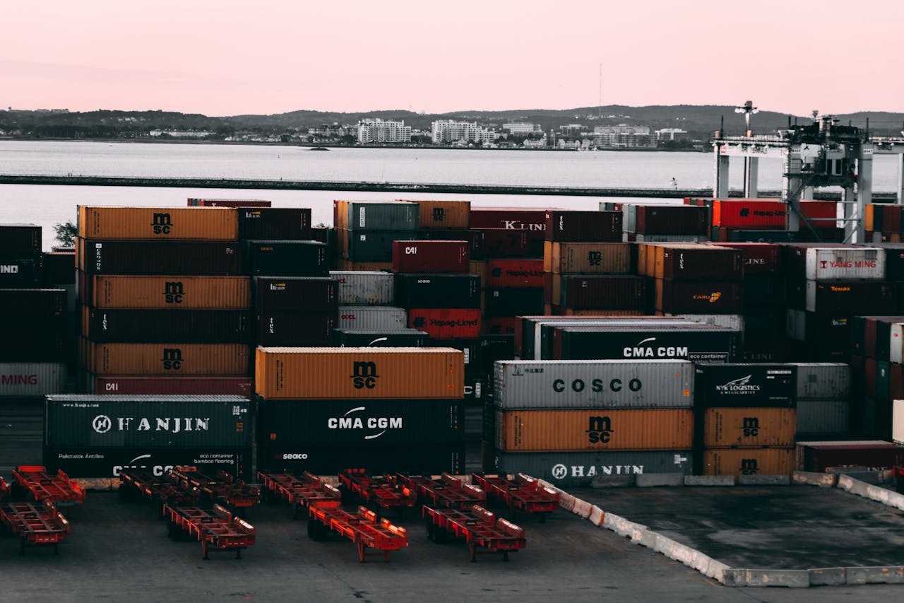 pexels-photo-2091159 A bustling container yard at a seaport with shipping containers stacked and ready for transport at twilight.